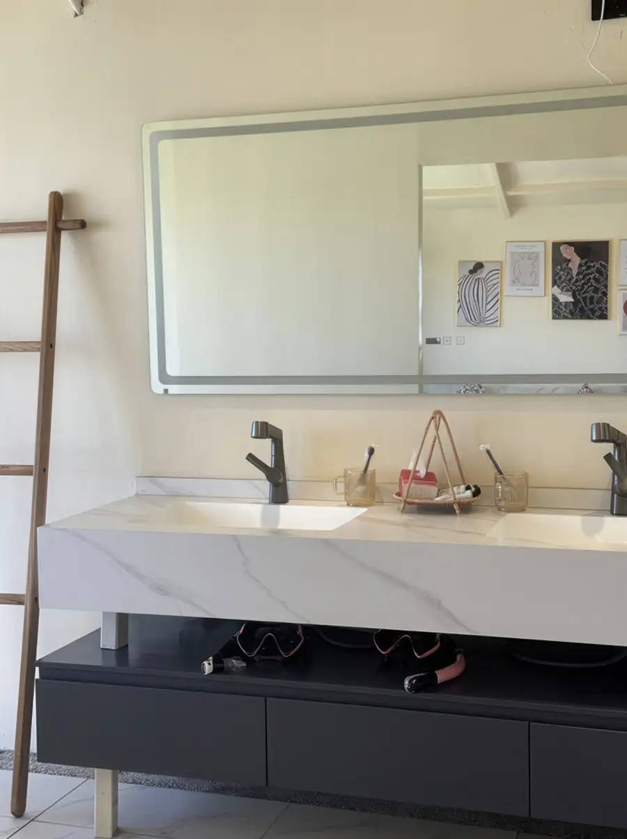 A bright and airy bathroom at Jelly Sea Resort offering a generous double vanity with light wood finishes, twin backlit mirrors, elegant washbasins, and an electric shower.