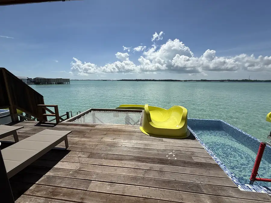Relaxing in a private glass-sided pool on a sunlit balcony at Jelly Sea Resort. Enjoy barefoot luxury and clear Semporna Archipelago views from this floating paradise.