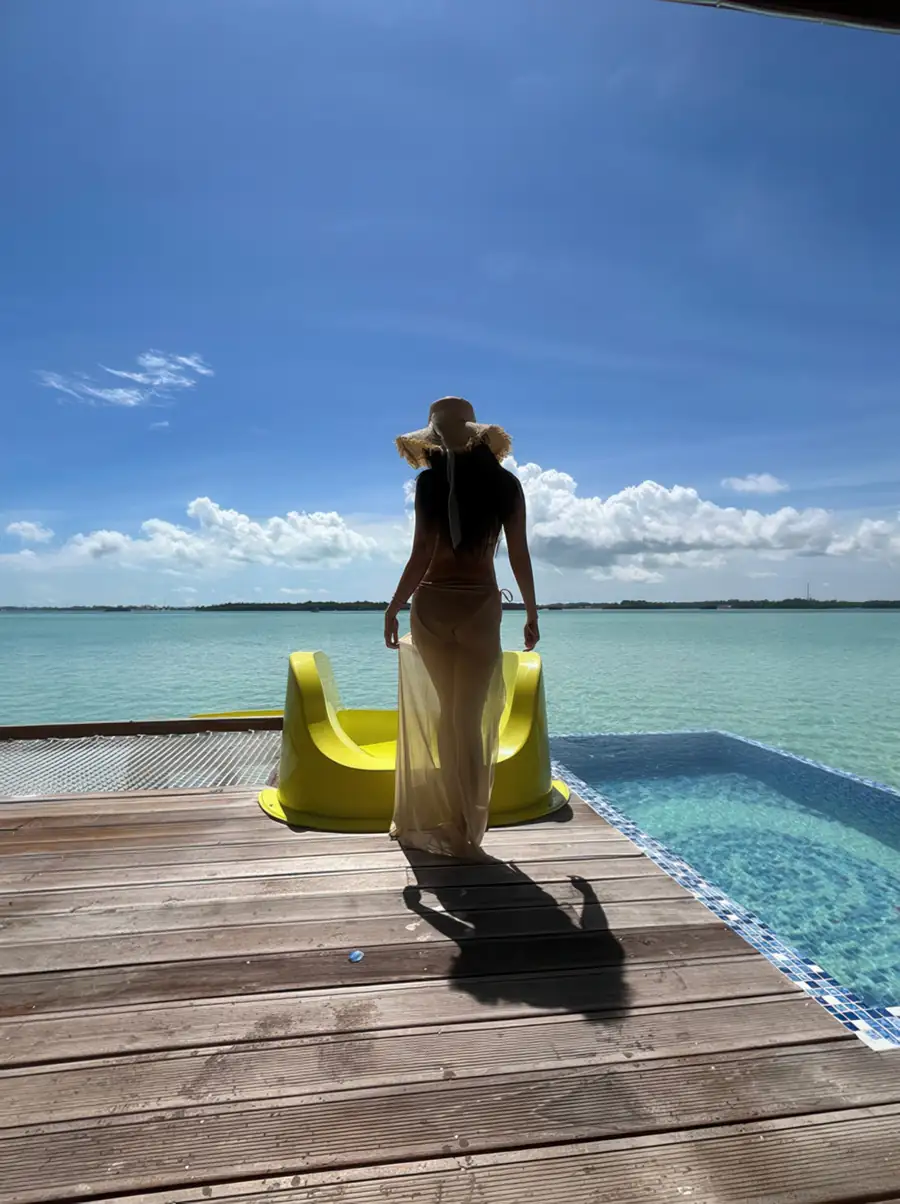Guest at the direct-to-sea water slide on an oceanview balcony with a private glass-sided pool at Jelly Sea Resort. Enjoy barefoot luxury and clear Celebes Sea views from this Semporna getaway.
