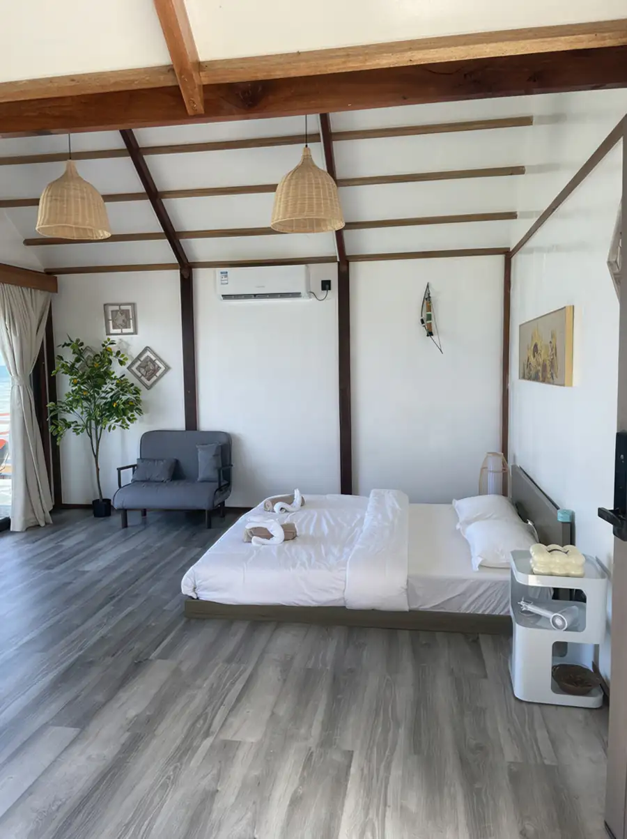 A cozy bedroom at Jelly Sea Resort near Semporna featuring a large bed, modern style decor, and authentic wooden floors with glossy hardwood floors, including aircon.