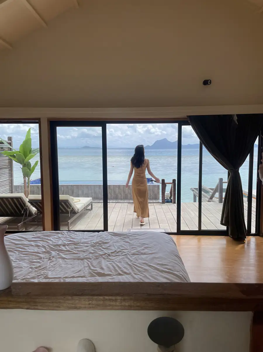 A stunning bedroom at Jelly Sea Resort near the Tun Sakaran Marine Park where the bed faces large glass doors opening onto the private balcony with seaviews and a pool, cooled by air con.