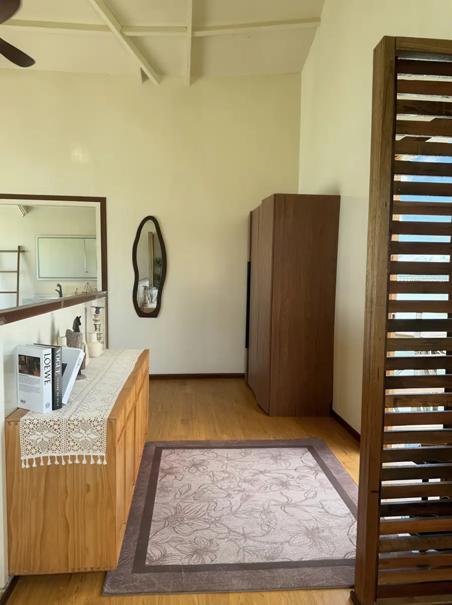 A functional room at Jelly Sea Resort near Semporna featuring a wooden vanity, floral rug, and rustic timber floor with smooth wooden boards, all kept comfortable with air conditioning.