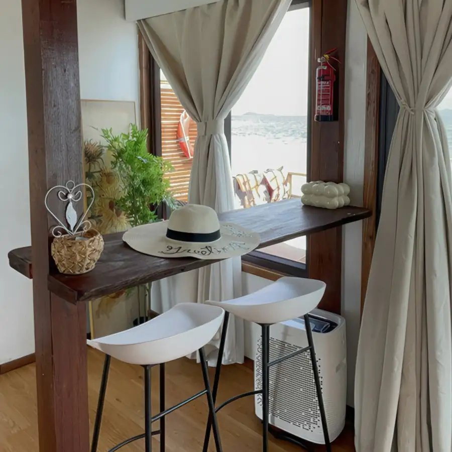 A cozy room at Jelly Sea Resort near Semporna with a wooden bar area, traditional style decor, and rustic timber floor with smooth wooden boards, featuring air conditioning.