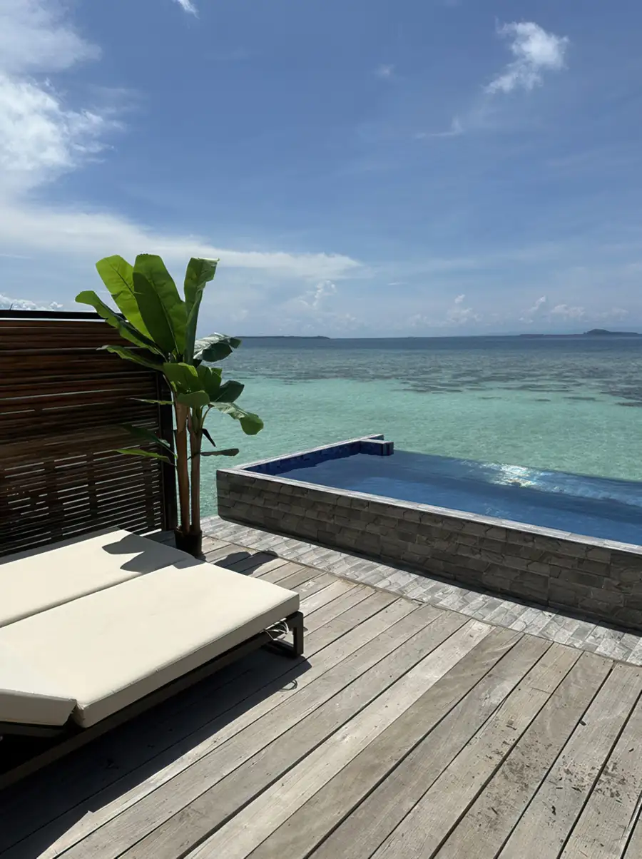 Guest relaxing in a private glass-front plunge pool on a sunlit balcony at Jelly Sea Resort. Enjoy the raw beauty of Semporna from this unique retreat above the marine sanctuary.