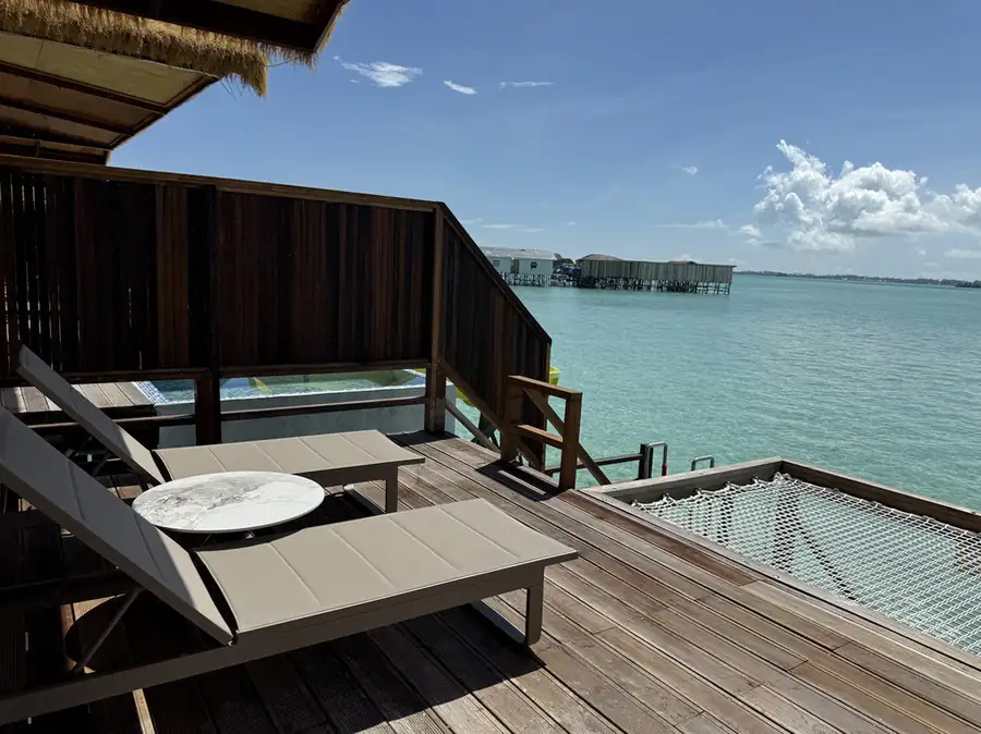 Private sunlit terrace featuring a suspended mesh deck and pink heart float at Jelly Sea Resort. A beautiful floating paradise perched over the crystal-clear Semporna waters.