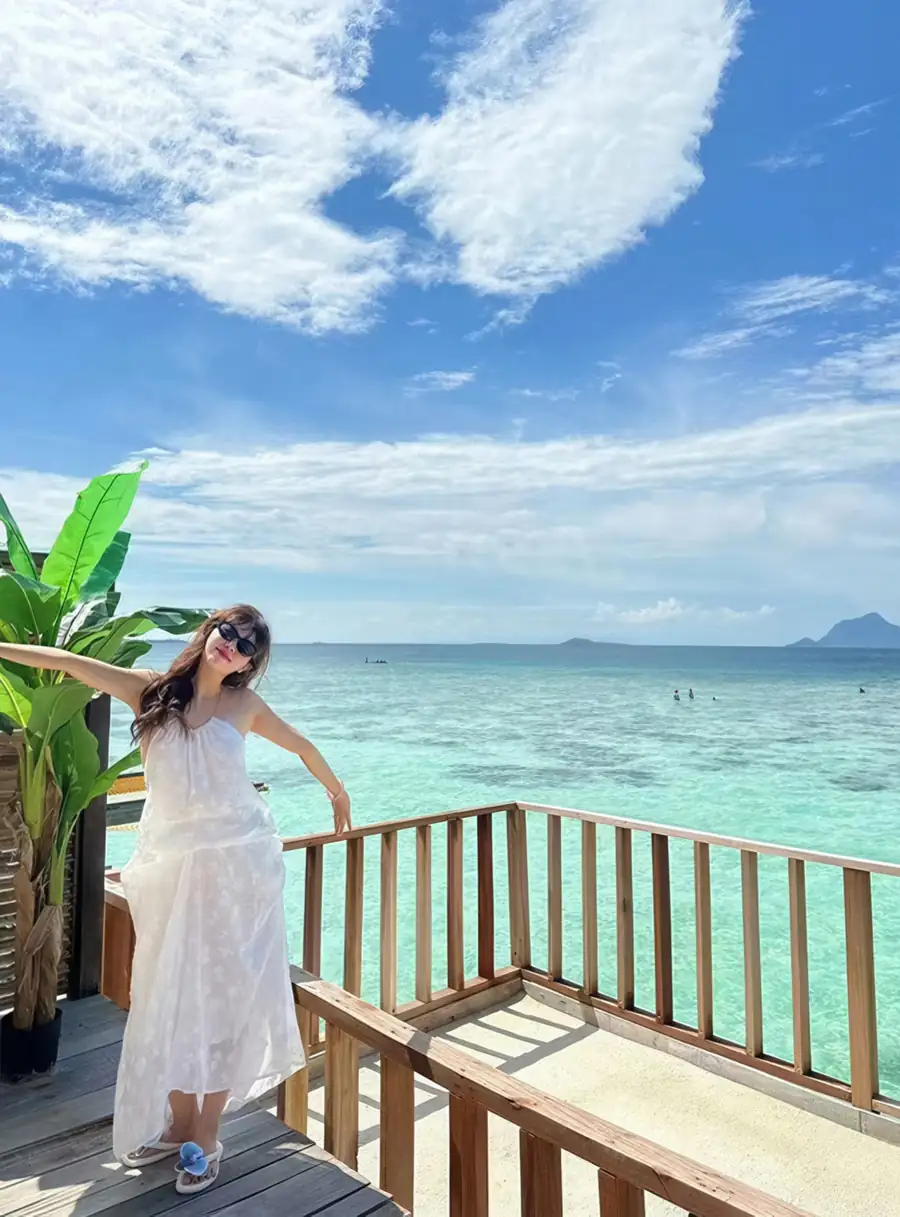 A guest enjoying the cool tropical breeze on a private ocean-facing sun balcony at Jelly Sea Resort. A breathtaking Semporna getaway perched above the crystal-clear Celebes Sea.