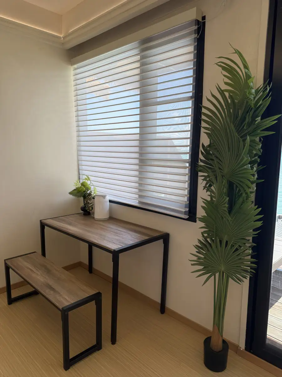 A sleek bedroom at Jelly Sea Resort near Bum Bum Island featuring a modern wooden desk by the window, smooth wooden boards, and air conditioning.
